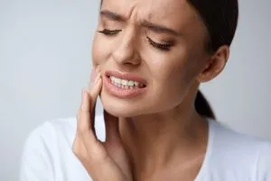 woman holding face in pain
