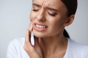 woman holding face in pain