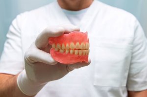 man holding denture model
